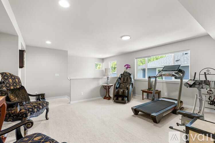 A spacious room with a treadmill, exercise bike, and other workout equipment.