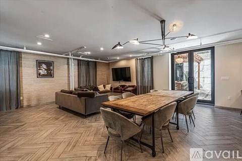 A spacious living room with a wooden dining table and chairs.