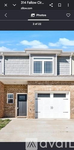 A house with a grey garage door and a black door.