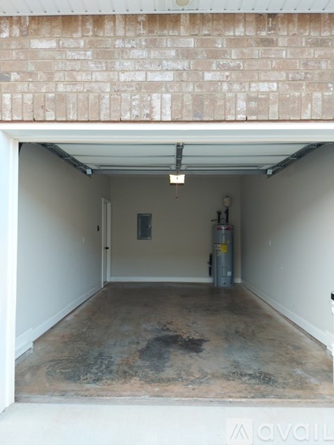 A large empty room with a concrete floor and a brick wall above it.