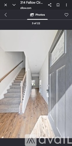 A hallway with wooden floors and a staircase.