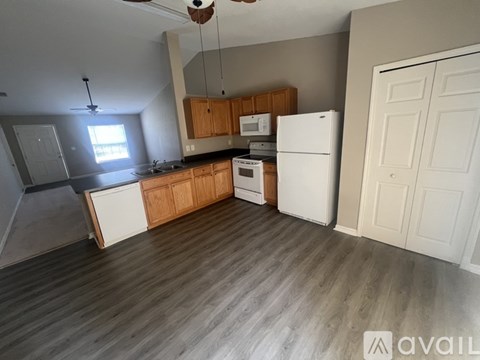 A kitchen with white appliances and wooden cabinets.