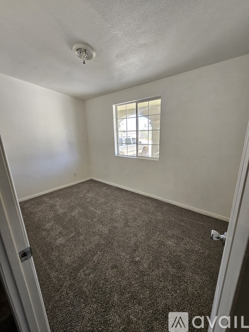 A room with a carpeted floor and a window.