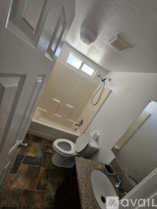 A bathroom with a toilet, sink, and shower.