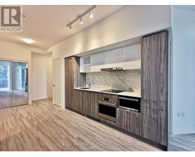 A modern kitchen with wooden cabinets and a marble backsplash.