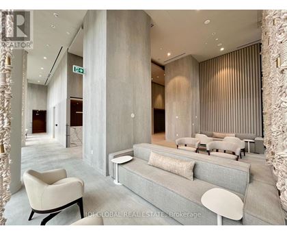 A modern living room with a grey sofa and a white chair.