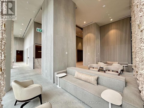 A modern living room with a grey sofa and a white chair.