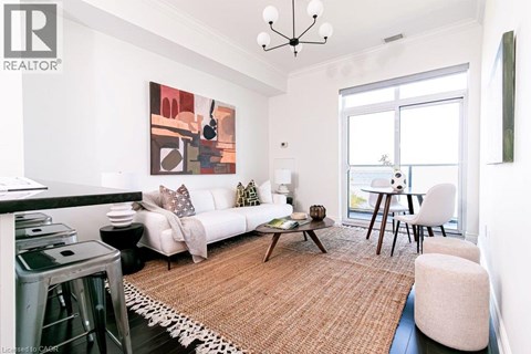 A living room with a white couch, a coffee table, and a painting on the wall.