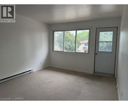 A room with a door, windows and a carpeted floor.
