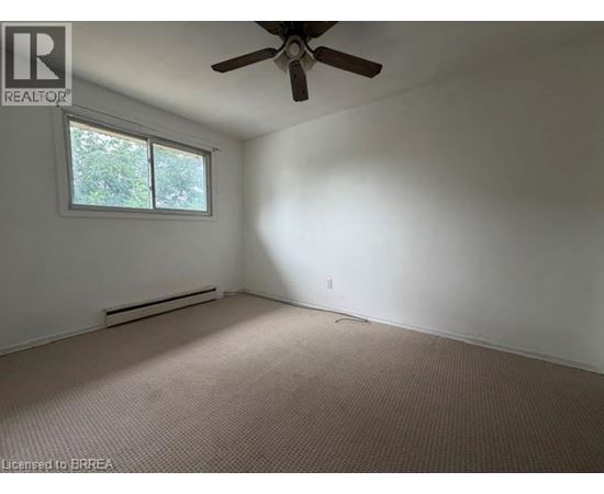 A room with a ceiling fan and a window.