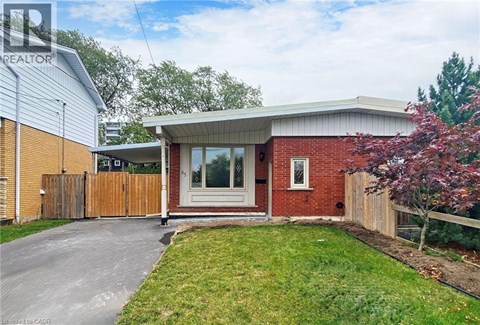 A house with a red brick exterior and a white door is for sale.