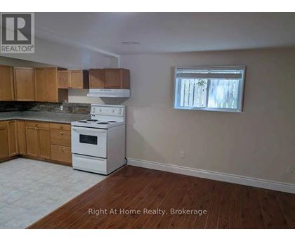 A kitchen with wooden cabinets and a white stove top oven.