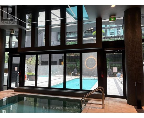 A pool area with a glass wall and a pool table.