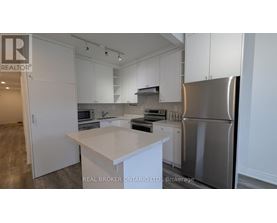 A modern kitchen with white cabinets and stainless steel appliances.