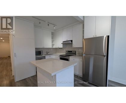 A modern kitchen with white cabinets and stainless steel appliances.