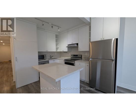 A modern kitchen with white cabinets and stainless steel appliances.