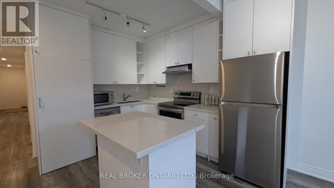 A modern kitchen with white cabinets and stainless steel appliances.