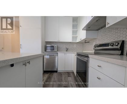A kitchen with white cabinets and a microwave above the dishwasher.
