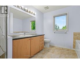 A bathroom with a window showing trees outside.