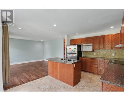 A kitchen with wooden cabinets and a refrigerator.