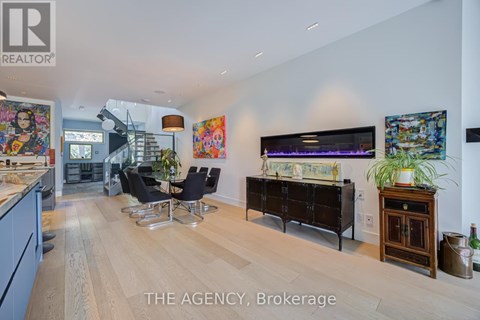A living room with a wooden floor and a large painting on the wall.