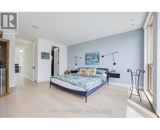 A bedroom with a bed, a nightstand, and a chair.