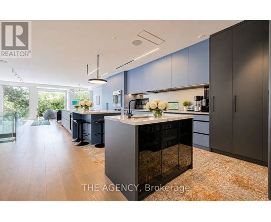 A modern kitchen with dark grey cabinets and a central island.