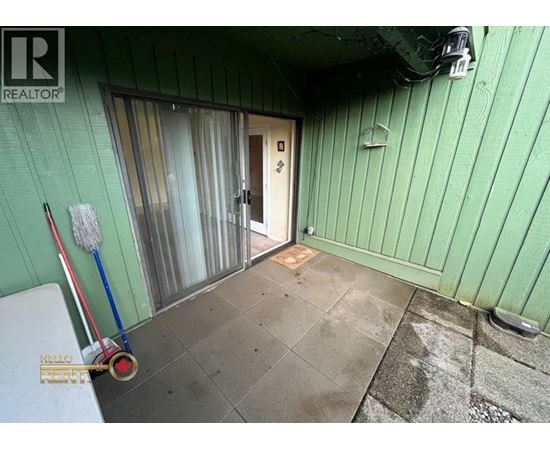 A room with green walls and a door leading outside.