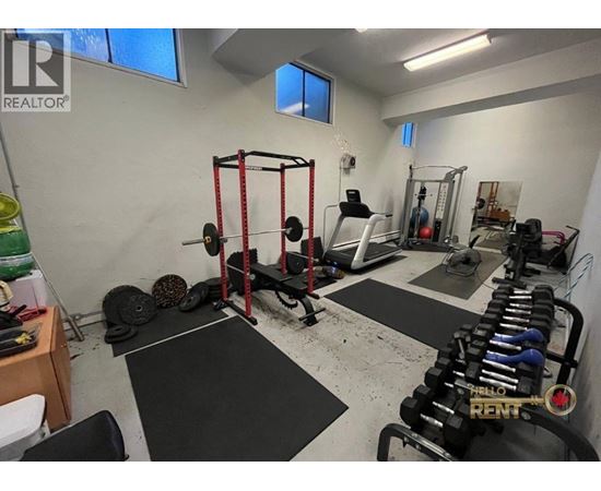 A gym with a variety of equipment including weights and a squat rack.