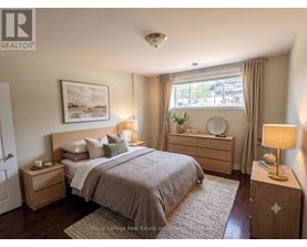 A bedroom with a large bed, nightstands, and a window with curtains.