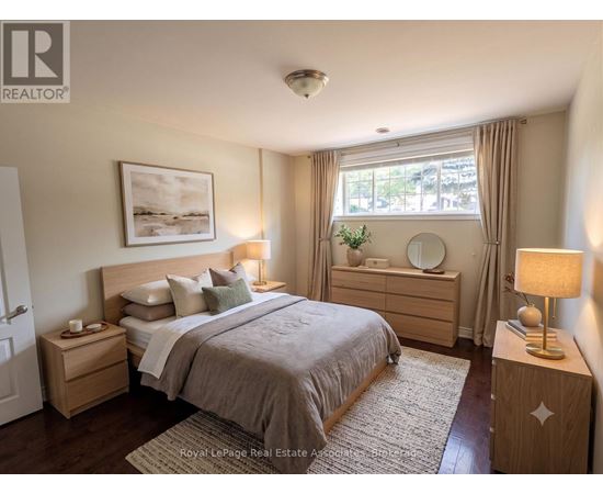 A bedroom with a large bed, nightstands, and a window with curtains.