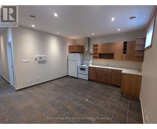 A kitchen with brown cabinets and a white fridge.