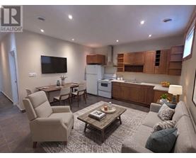 A living room with a couch, chairs, a coffee table, and a television.