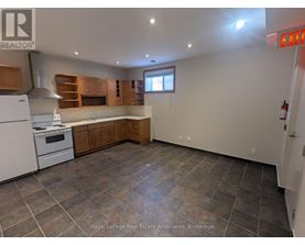 A kitchen with a white stove and wooden cabinets.