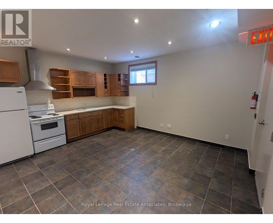 A kitchen with a white stove and wooden cabinets.