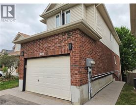 A house with a garage door and a brick wall.