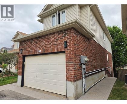 A house with a garage door and a brick wall.