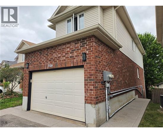 A house with a garage door and a brick wall.