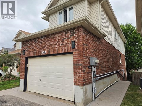 A house with a garage door and a brick wall.