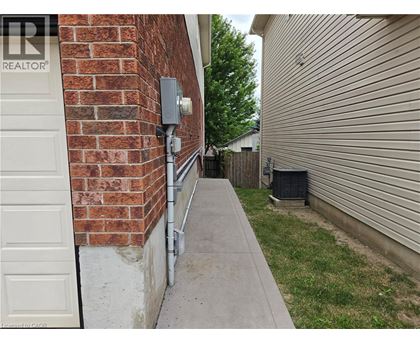 A white door is on the left of a brick wall.
