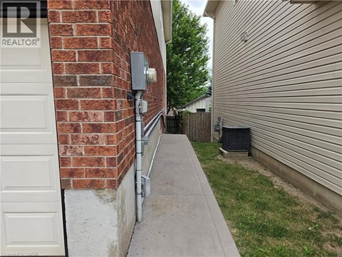 A white door is on the left of a brick wall.