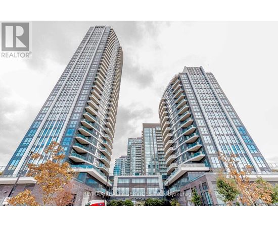 Two tall buildings with balconies are in the foreground with a cloudy sky in the background.