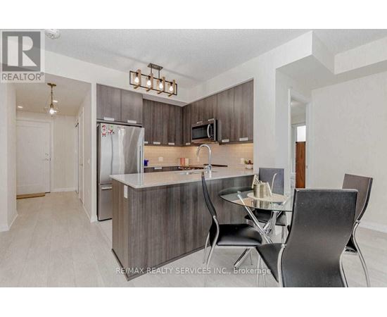 A modern kitchen with a dining table set for two.