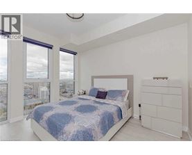 A bedroom with a large bed and a view of the city.