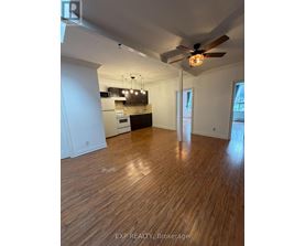 A room with wooden flooring and a ceiling fan.