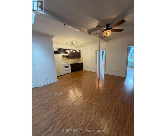 A room with wooden flooring and a ceiling fan.