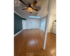 A room with wooden flooring and a ceiling fan.