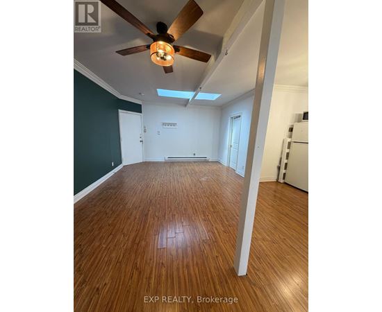 A room with wooden flooring and a ceiling fan.