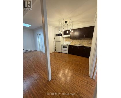 A kitchen with wooden floors and a white stove top oven.