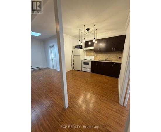 A kitchen with wooden floors and a white stove top oven.